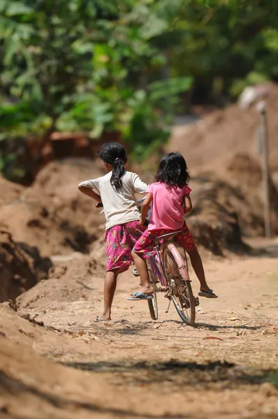 Twee meisjes op één fiets — Stockfoto