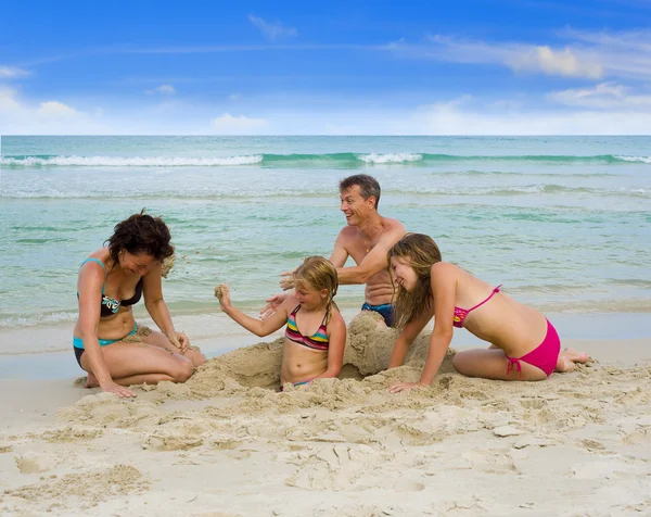 Família feliz brincando na praia Fotos De Bancos De Imagens