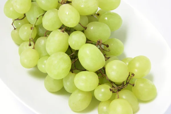 Ramo de uvas verdes en la placa —  Fotos de Stock