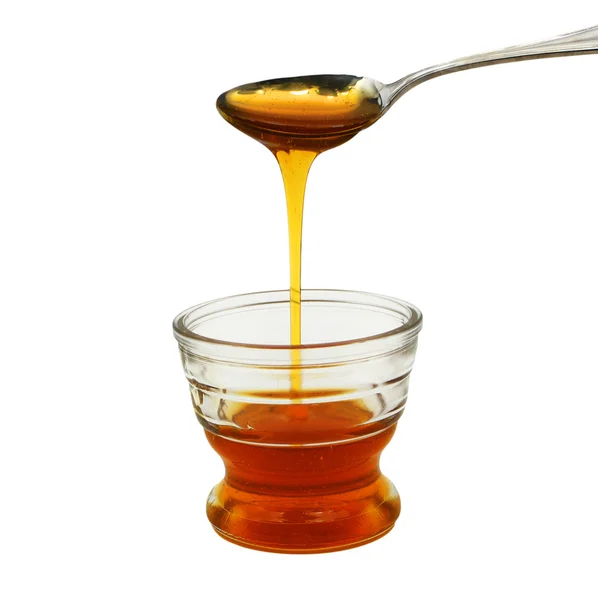 stock image Honey pouring into small glass bowl