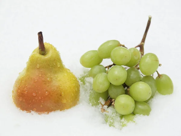 Grapes and pear on a snow — Stock Photo, Image