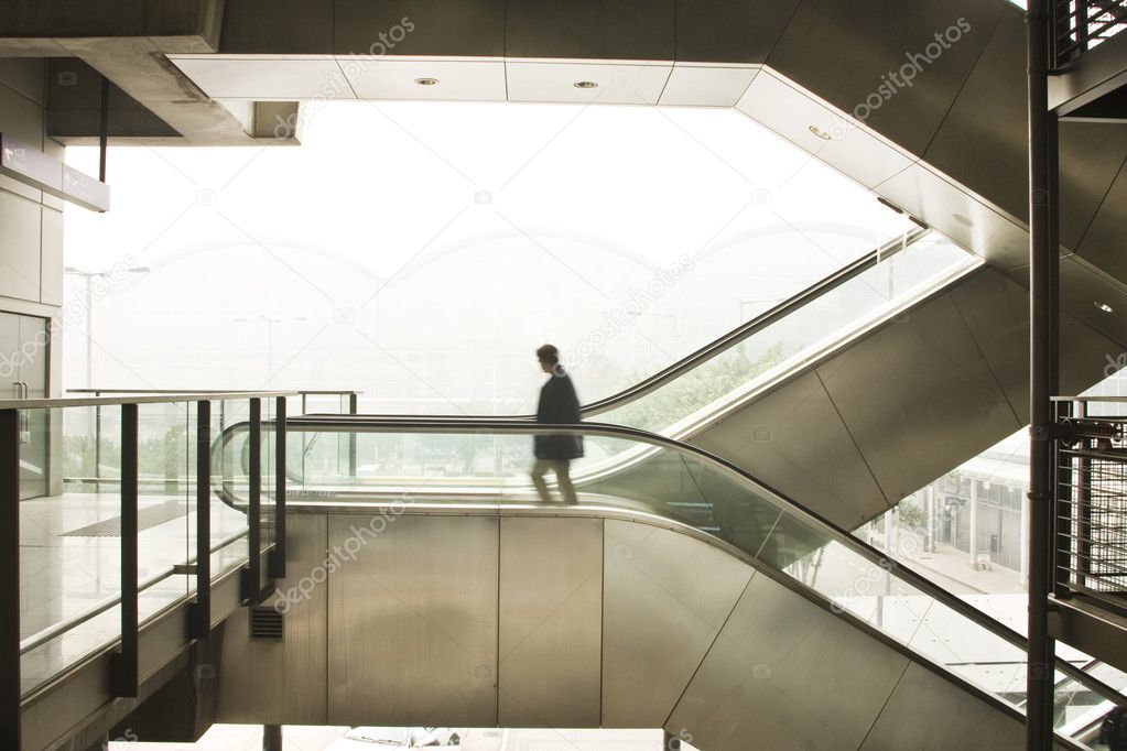 Man move on escalator.