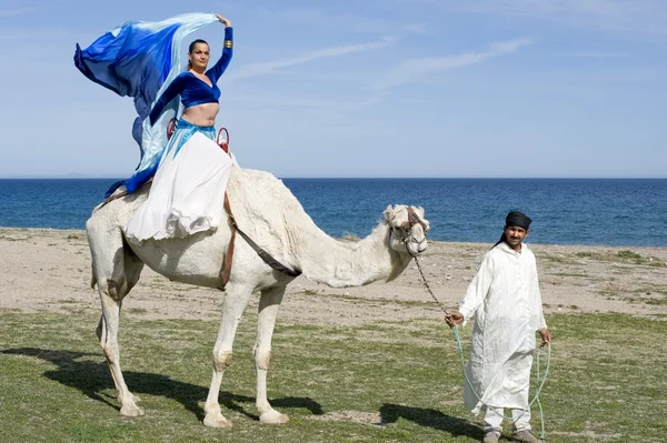 Танцор живота, сидящий на верблюде — стоковое фото