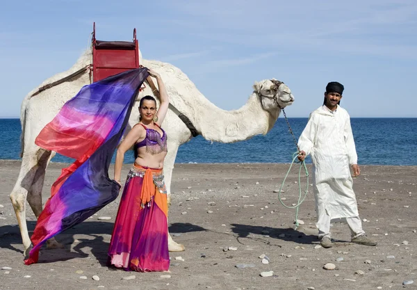 Танцовщица живота рядом с верблюдом — стоковое фото