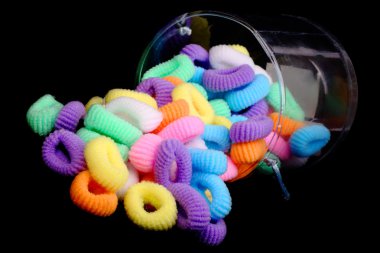 Colored elastics on black background clipart