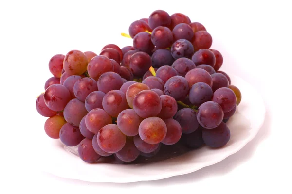 Виноград на белой тарелке — стоковое фото