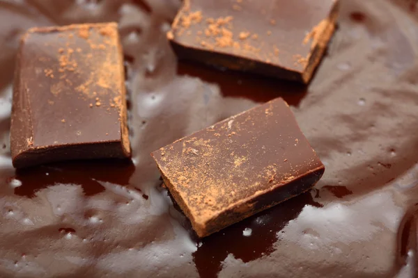 Pieces of dark chocolate in the melted c — Stock Photo, Image