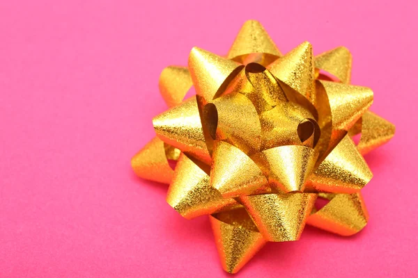 Gold bow on pink velvet paper background — Stock Photo, Image