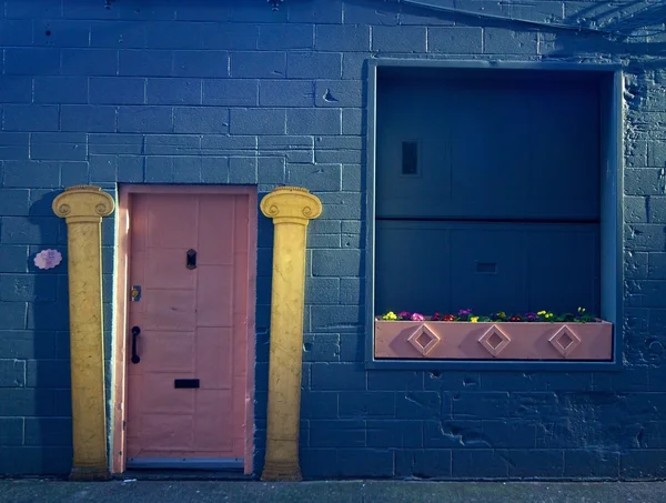Pink door with yellow pillars — Stock Photo, Image