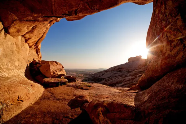 Jaskinia i zachód słońca w górach pustyni — Zdjęcie stockowe