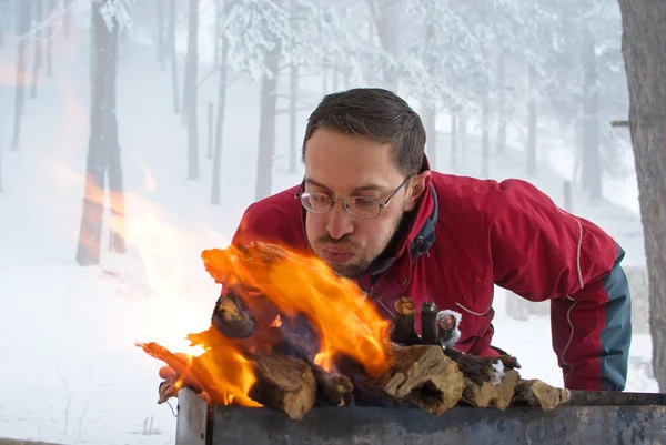 Άνθρωπος fanning πυρκαγιά στη σχάρα — Φωτογραφία Αρχείου