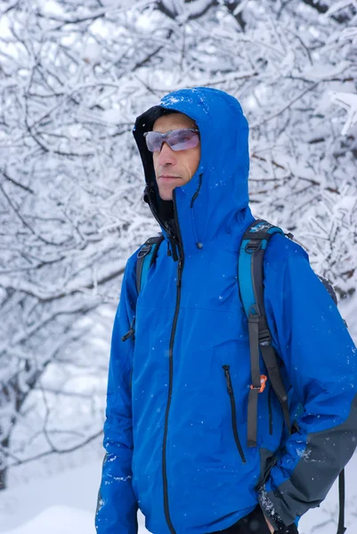 Batohem muž v zimním lese — Stock fotografie