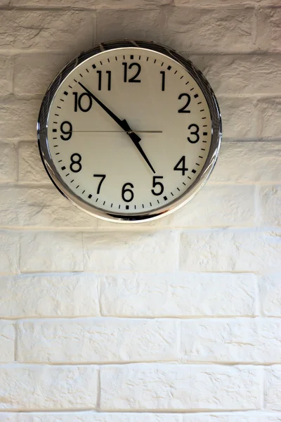 Reloj en la pared de ladrillo blanco — Foto de Stock