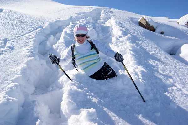 Lachende vrouw op een pad van de sneeuw in de bergen — Stockfoto