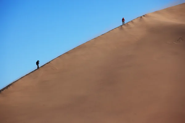 Two silhouette on dune in sand storm — Stock Photo, Image