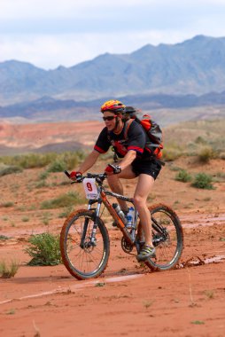 Mountain biker racing in desert mountains clipart