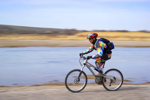 Velocidade movimento mountain biker ao lado do rio — Fotografia de Stock