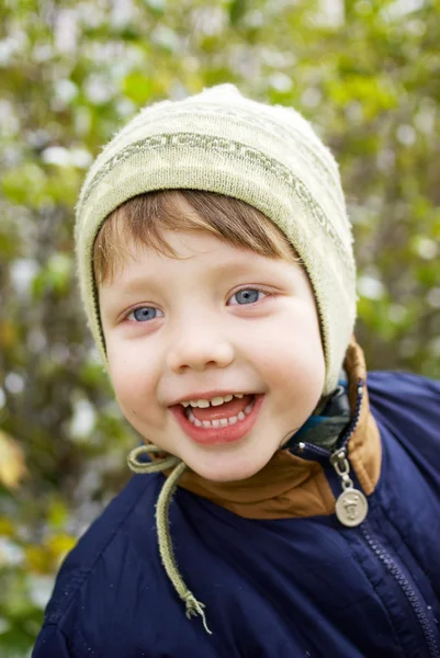 Смеющийся мальчик в осеннем парке — стоковое фото