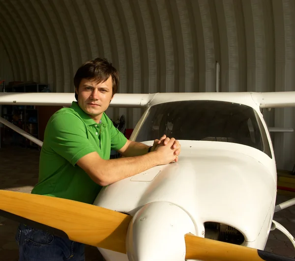 Молодой человек рядом с маленьким самолетом — стоковое фото