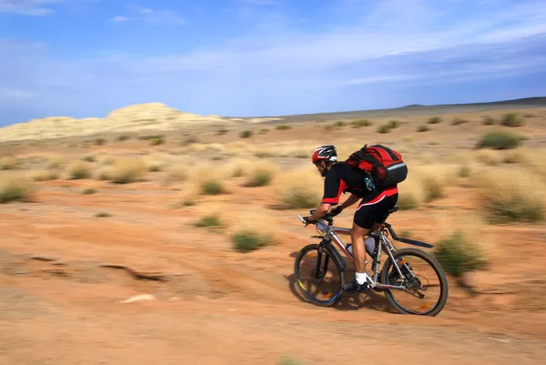 Speed motion mountain biker on desert — Stock Photo, Image