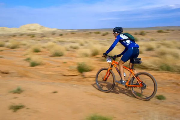在沙漠上的议案山骑自行车的速度 — 图库照片