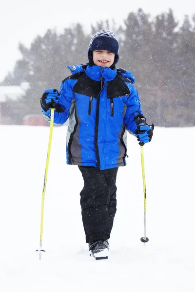 Мальчик с лыжными клюшками — стоковое фото