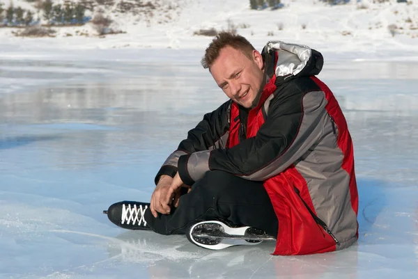Homme reposant sur la glace après avoir chevauché — Photo