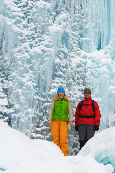 Paar backpackers en ijs waterval — Stockfoto