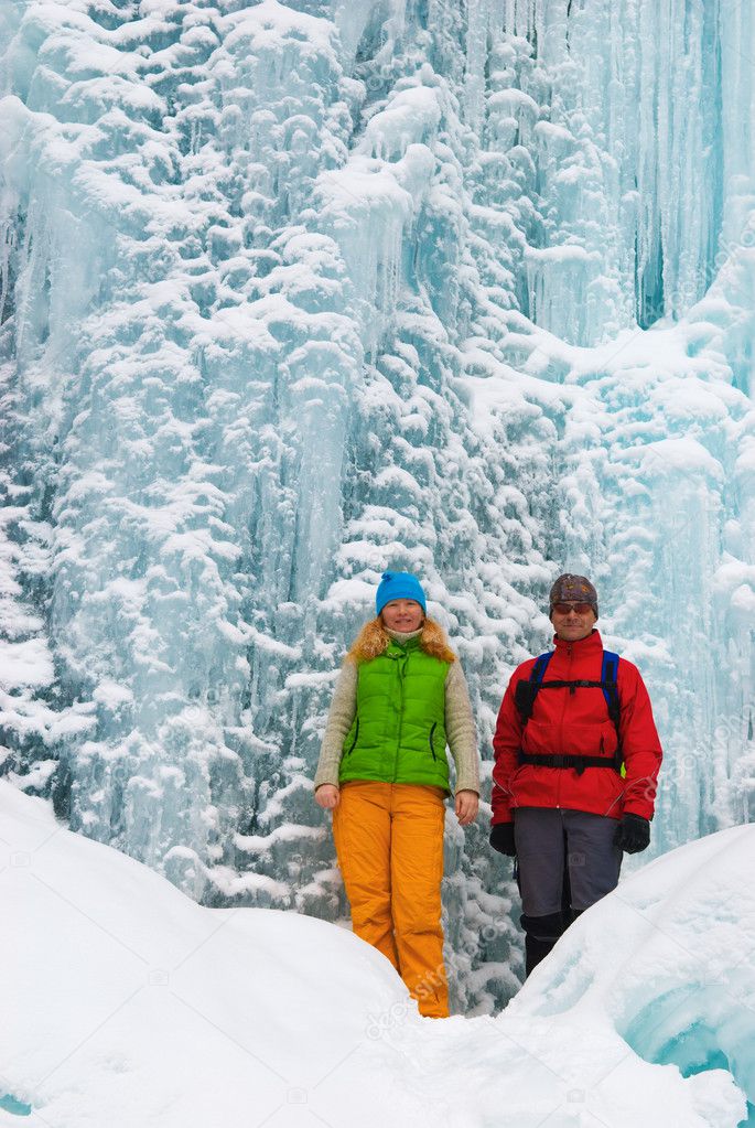 Couple backpackers and ice waterfall
