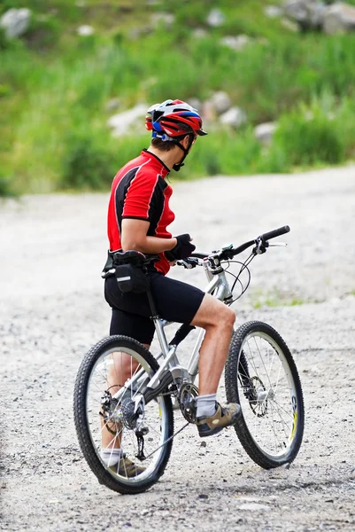 Motociclista de montaña espera en carretera rural —  Fotos de Stock