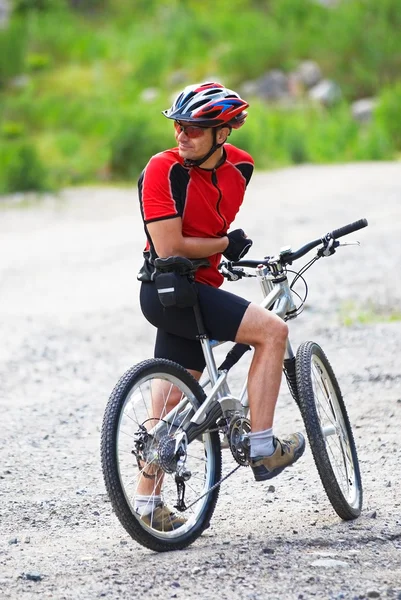 Горный велосипедист ждет на сельской дороге — стоковое фото