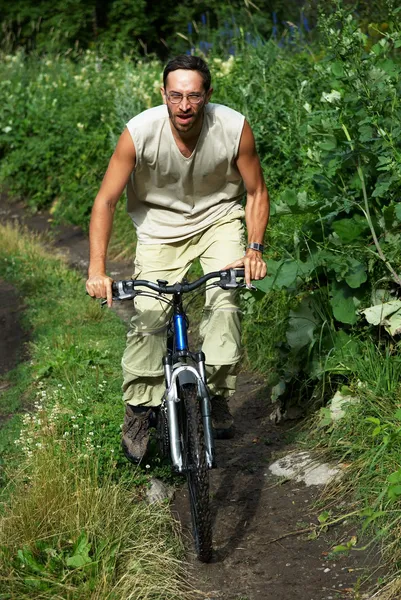 Mountain biker on old rural road — Stock Photo, Image
