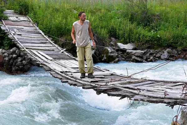 Człowiek na stary most wiszący — Zdjęcie stockowe