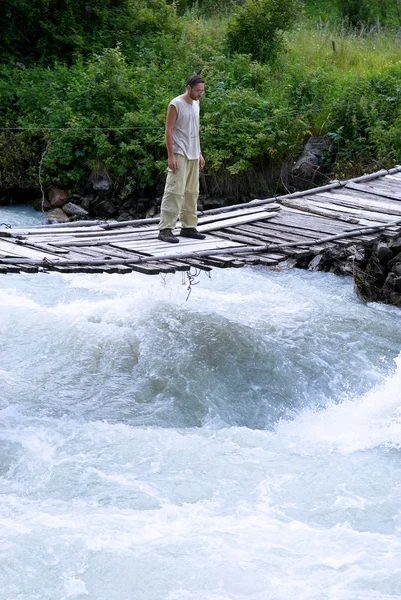 Homem na velha ponte suspensa — Fotografia de Stock