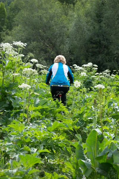 骑着自行车在森林中的女孩 — 图库照片