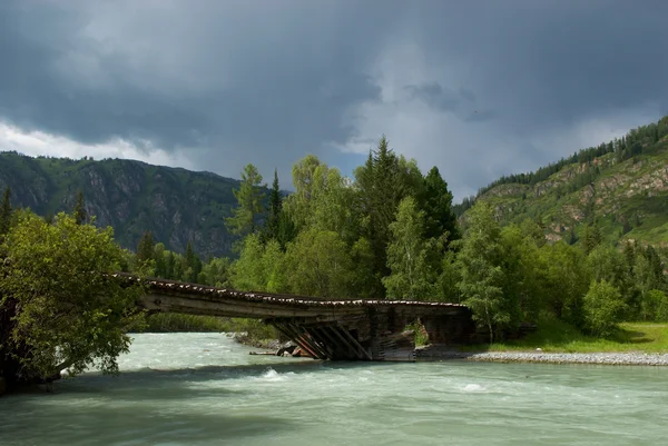 Bergrivier en oude houten brug — Stockfoto