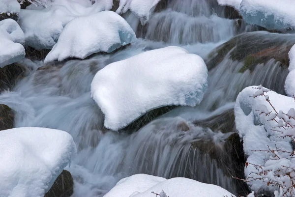 Ruisseau de montagne d'hiver pendant les chutes de neige — Photo