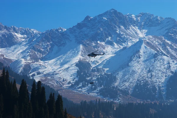 Helicopter with cargo in high mountain — Stock Photo, Image