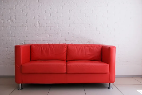 红色的沙发和白色砖墙 — 图库照片