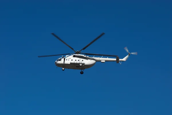 Mucha duży biały helikopter na błękitne niebo — Zdjęcie stockowe