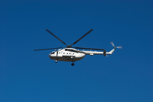Fly big white helicopter on blue sky