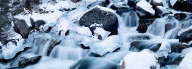 Cascades on a mountain river in winter clipart