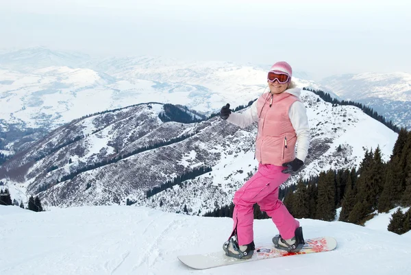 Веселая сноубордистка в розовой тряпке перед спуском — стоковое фото
