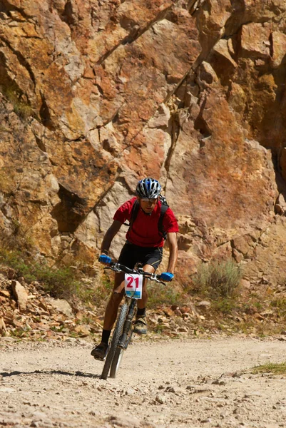 Mountainbike-åkaren racing nära klippor — Stockfoto