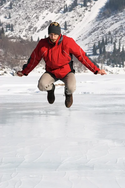Hlavní v červené skákání na zimní horské jezero — Stock fotografie