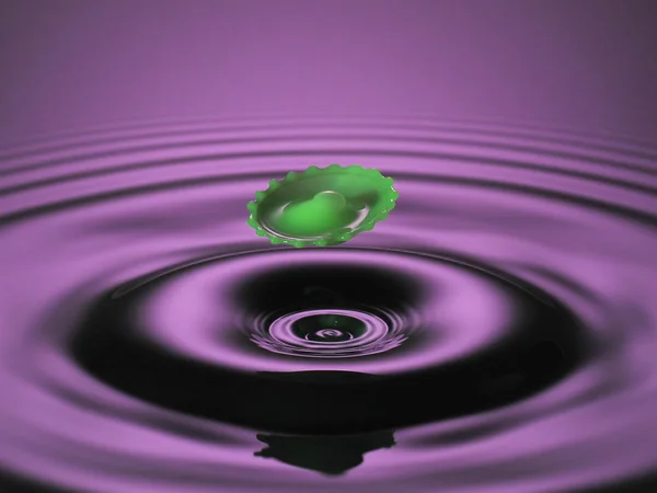 Hovering green splash on purple Stock Picture