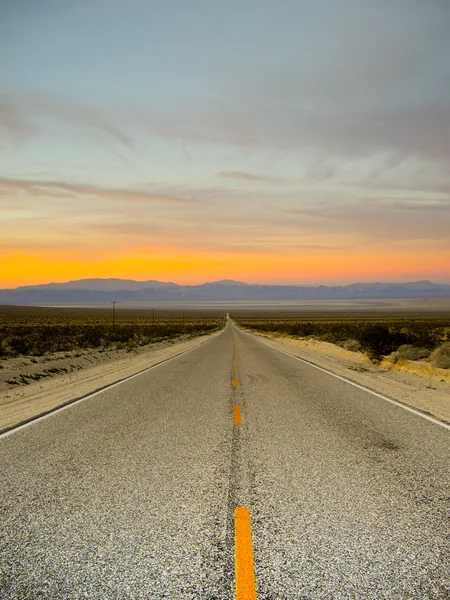 Desert highway vid solnedgången — Stockfoto
