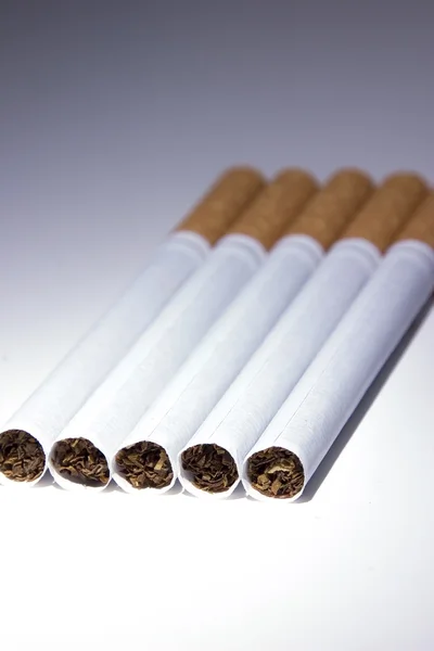 Vereinzelte Zigaretten unter Blaulicht — Stockfoto