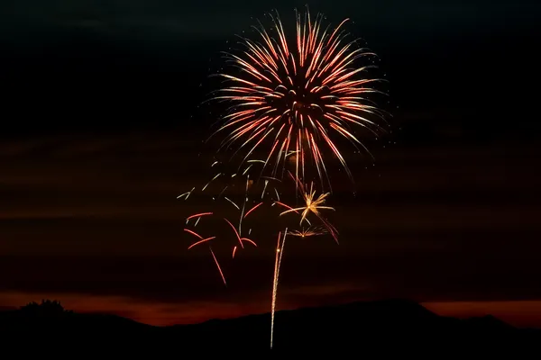 Fogos de artifício no céu durante o pôr do sol — Fotografia de Stock
