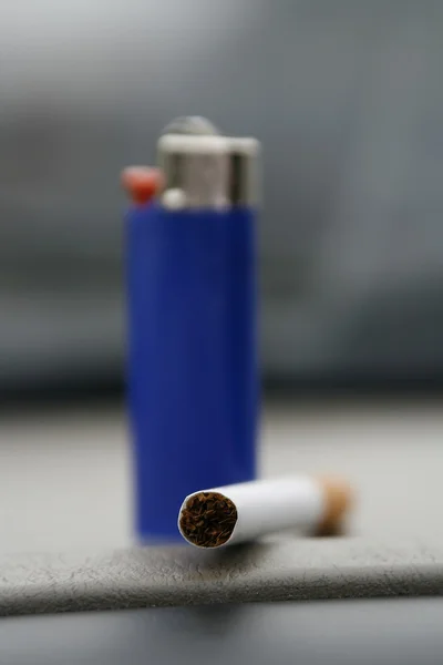 Blaues Feuerzeug und eine Zigarette — Stockfoto